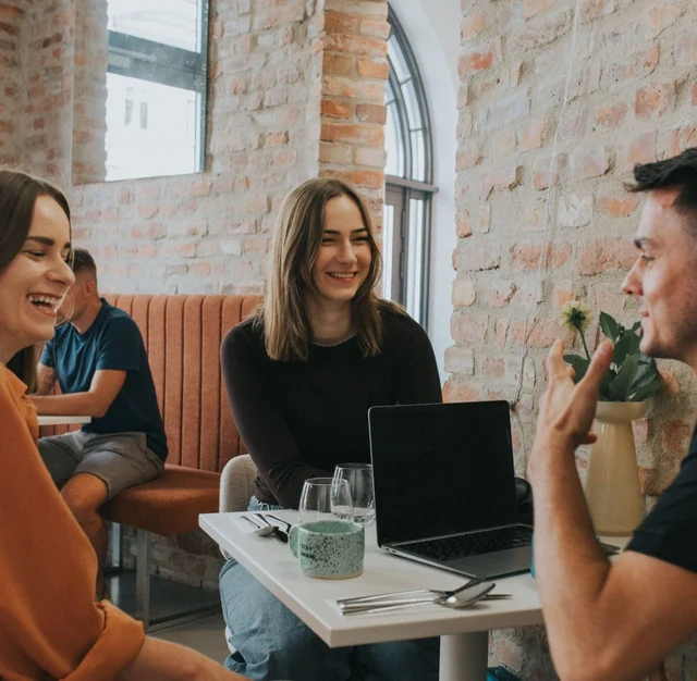 Rozmowa zespołu umami digital przy stoliku z laptopem